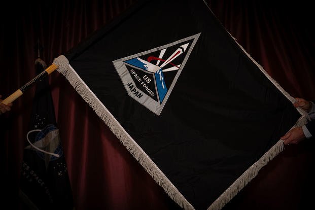 The official U.S. Space Forces-Japan flag is unveiled during the activation and assumption of command ceremony at Yokota Air Base, Japan