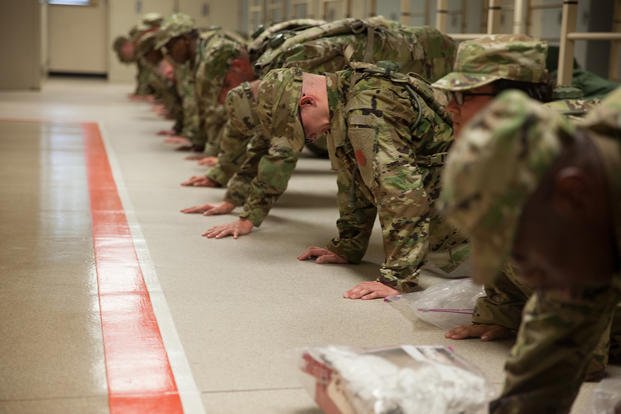 U.S. Army trainees assigned to Foxtrot 1st Battalion 34th Infantry Regiment conduct push-ups for corrective training in the barracks on the first day of basic combat training at Fort Jackson, S.C.