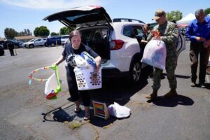 Courtney Bouma, a Navy dependent, arrives with items to be used for those who were evacuated after a small plane crashed early Thursday morning, May 22, 2025, in a heavily military community near San Diego, killing 6 and injuring 8.
