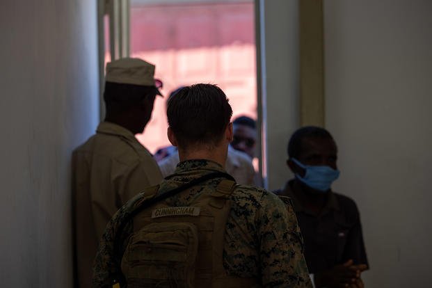 U.S. Marine Corps Cpl. Chase Cunningham, a squad leader with 1st Battalion, 8th Marine Regiment, 2d Marine Division, works alongside Haitian national police to escort patients during Continuing Promise 2022 in Jeremie, Haiti.