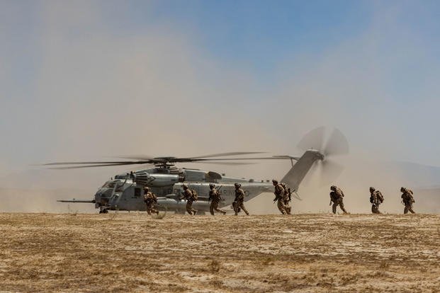 U.S. Marines maneuver away from a CH-53E Super Stallion helicopter after being transported as part of an exercise on Marine Corps Base Camp Pendleton, Calif.