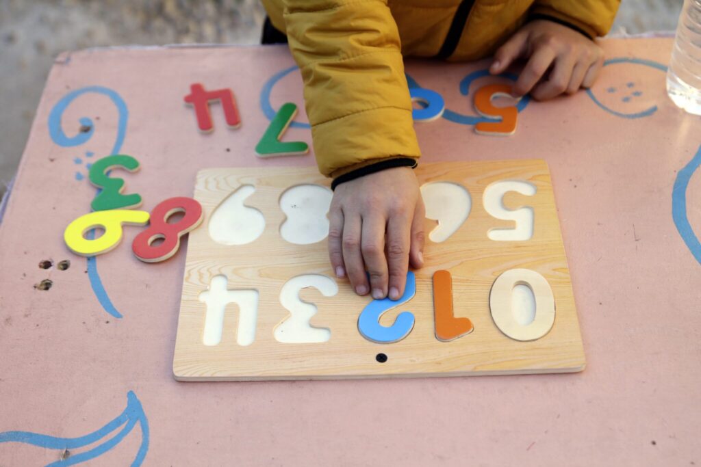 A boy plays with a wooden numbers puzzle. Sensory exercises like this are often used in special education classrooms. (Getty Images)