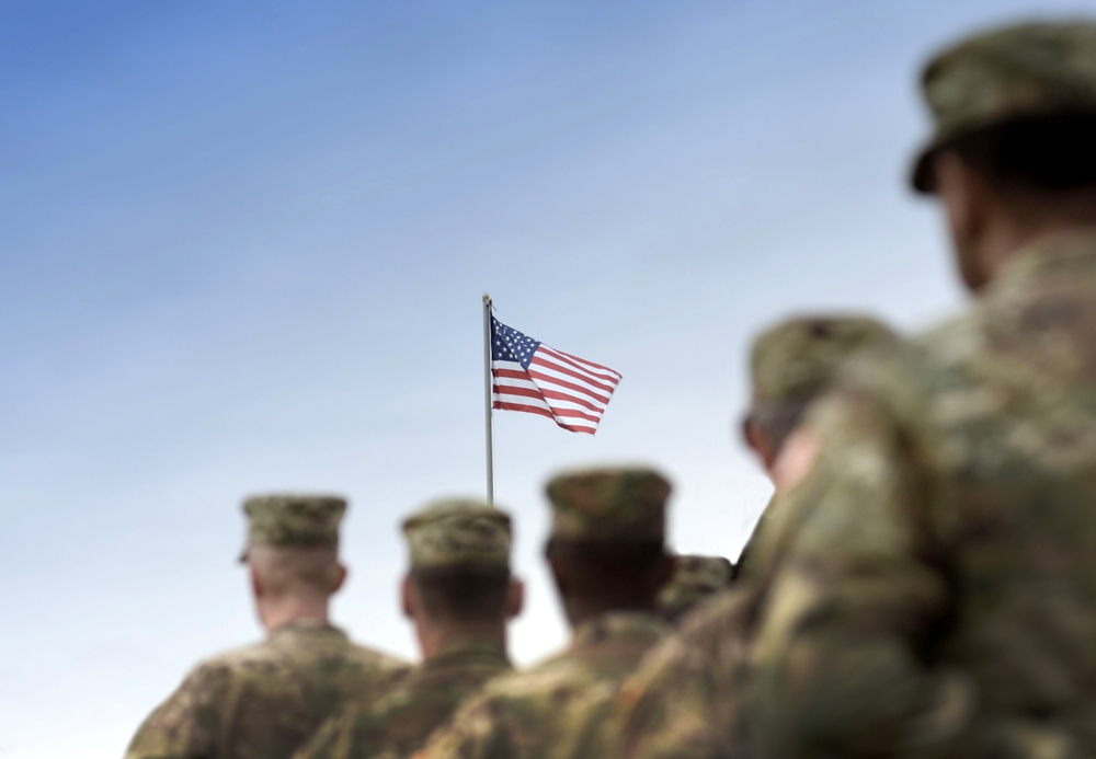 Soldiers standing at attention to flag