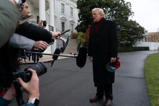 President Donald Trump talks to reporters outside the White House.