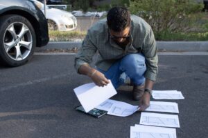 Jermaine Barkley crouches and organizes maps for other Flagstaff volunteers to follow on April 8, 2026.