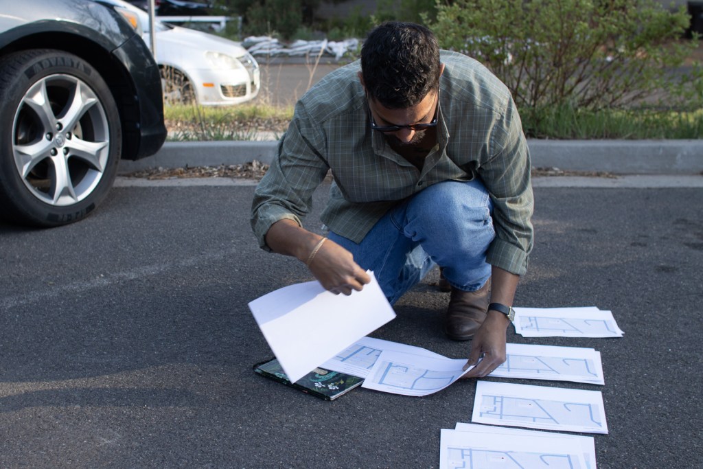 Jermaine Barkley crouches and organizes maps for other Flagstaff volunteers to follow on April 8, 2026.