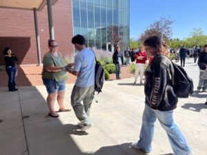 High school students unlock magnetic locking pouches containing their phones after class with a newly established a phone-free policy in 2024. After the success of cellphone bans nationwide, state lawmakers are turning to legislation restricting how much time students can look at screen. (Alixel Cabrera/Utah News Dispatch)