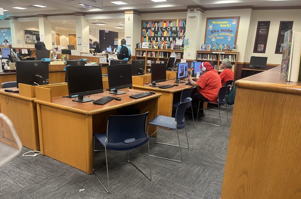 Patrons use free Wi-Fi at a public library in Chicago. For nearly 30 years, the E-Rate program has helped connect schools and libraries to the internet, but the Trump administration is reviewing the program. (Photo Robbie Sequeira/Stateline)